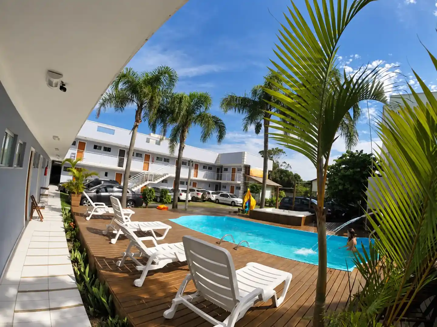 Pool courtyard with palm trees and sun loungers at Pousada das Estrelas